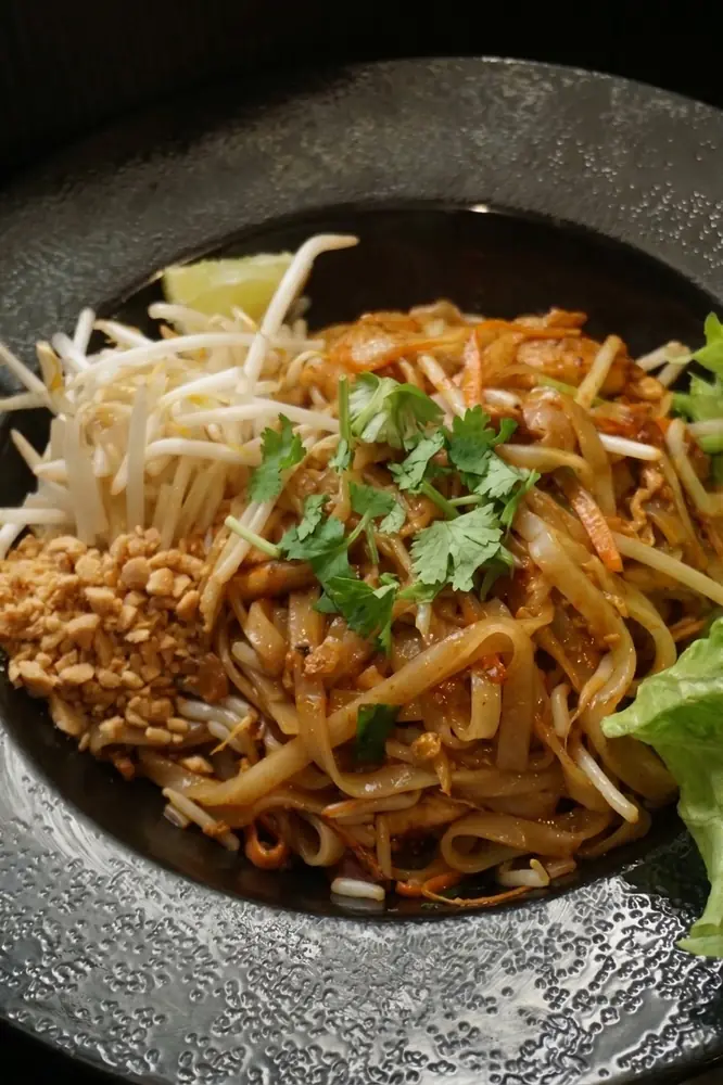 Pad thaï : nouilles de riz sautées, cacahuètes et coriandre